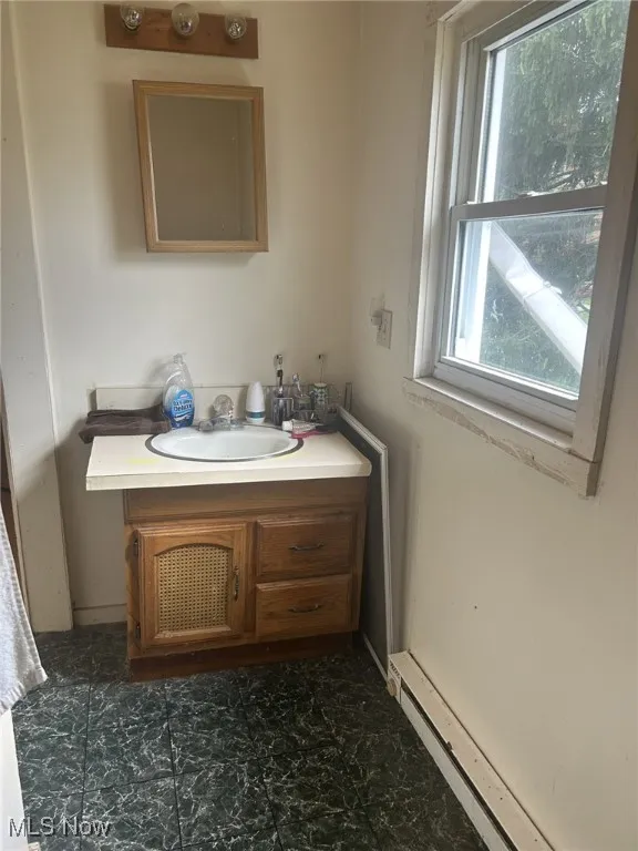 Bathroom featuring a baseboard radiator and​​‌​​​​‌​​‌‌​‌‌​​​‌‌​‌​‌​‌​​​‌​​ vanity