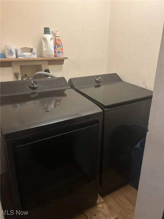 Laundry area featuring washing machine and clothes dryer and light wood-style floors