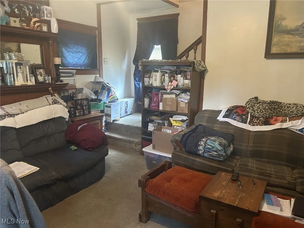Carpeted living area featuring stairs