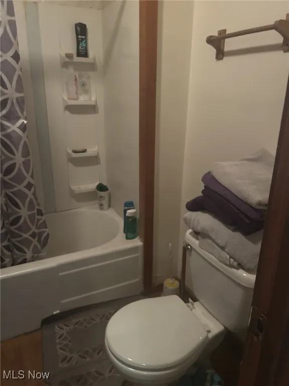 Full bath featuring toilet and shower / tub combo