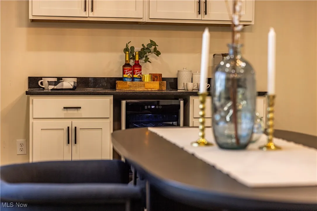 Bar featuring white cabinets and wine cooler