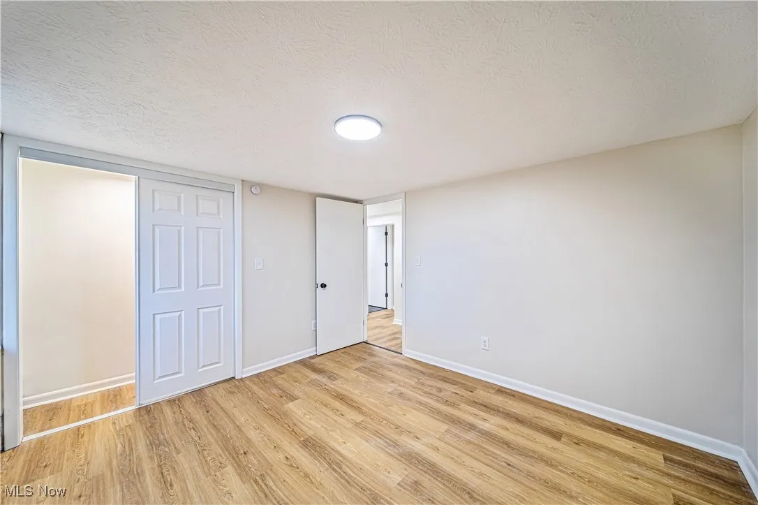 Unfurnished bedroom featuring a textured ceiling and light hardwood / wood-style floors