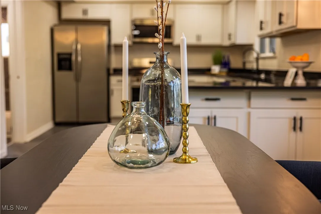 Kitchen featuring white cabinetry, stainless steel fridge, and sink