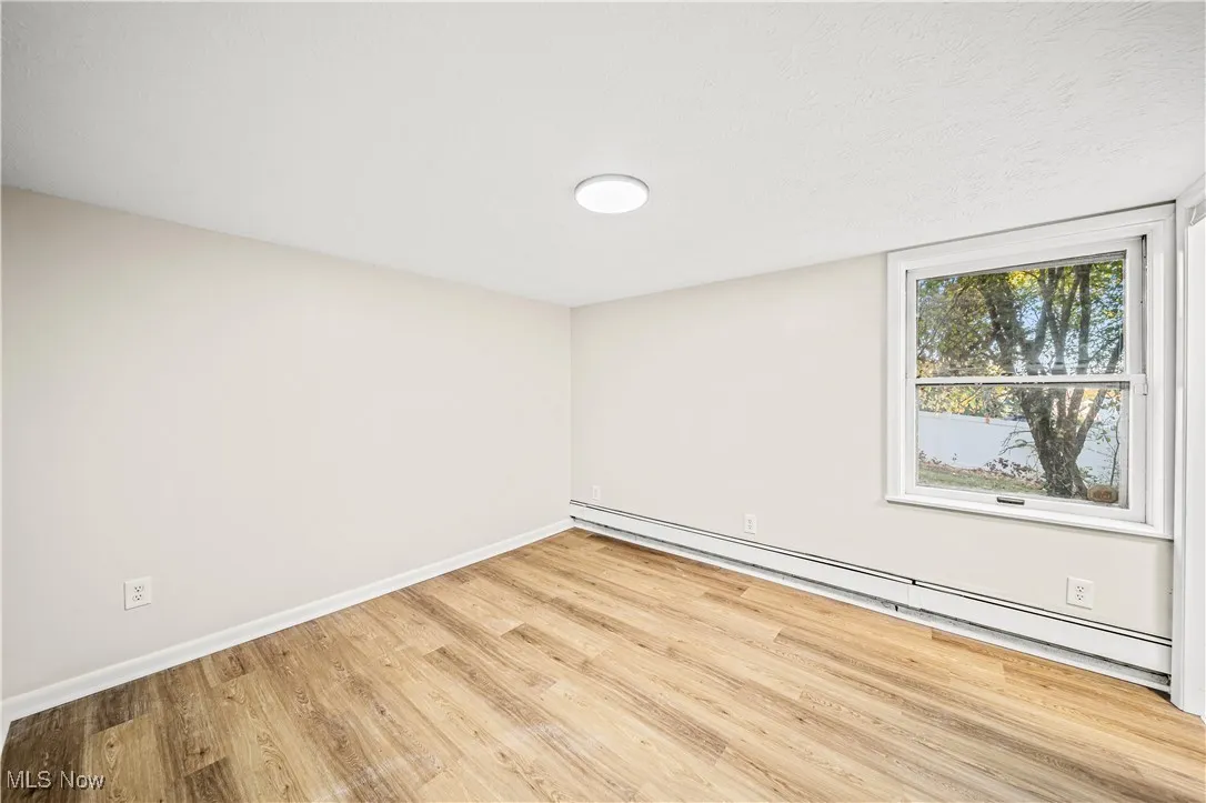 Spare room featuring light hardwood / wood-style floors and a baseboard heating unit