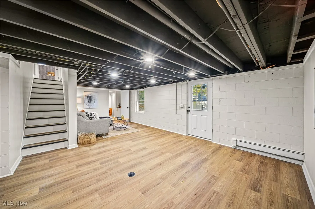 Basement featuring hardwood / wood-style flooring and baseboard heating