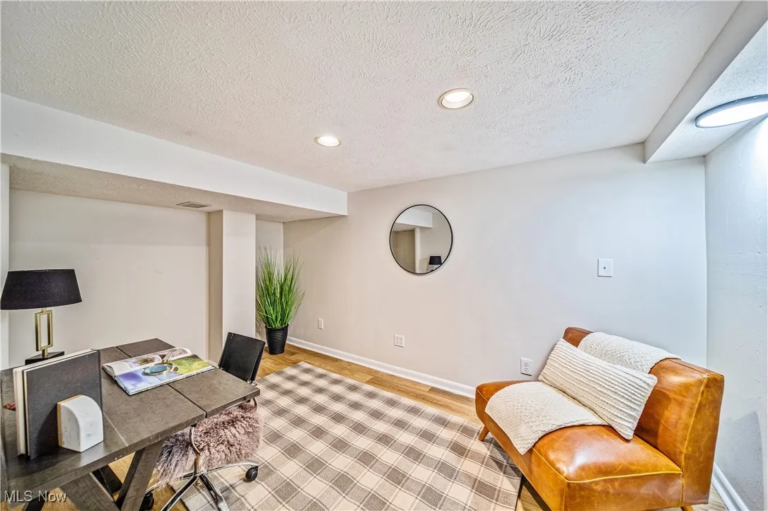 Office space with light hardwood / wood-style flooring and a textured ceiling