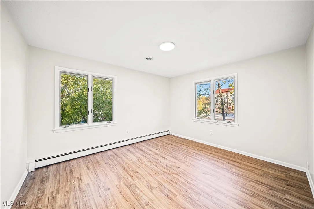 Spare room featuring hardwood / wood-style flooring and baseboard heating