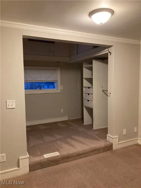 Unfurnished bedroom with ornamental molding and carpet floors