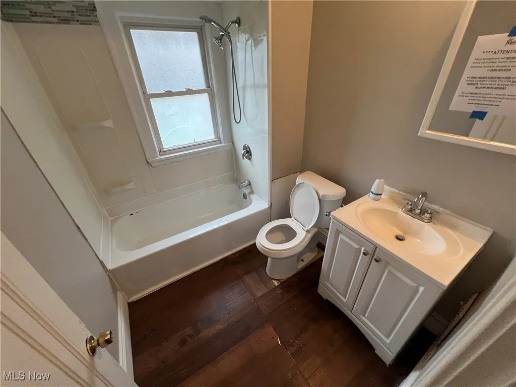 Bathroom featuring wood finished floors, vanity, and bathtub / shower combination