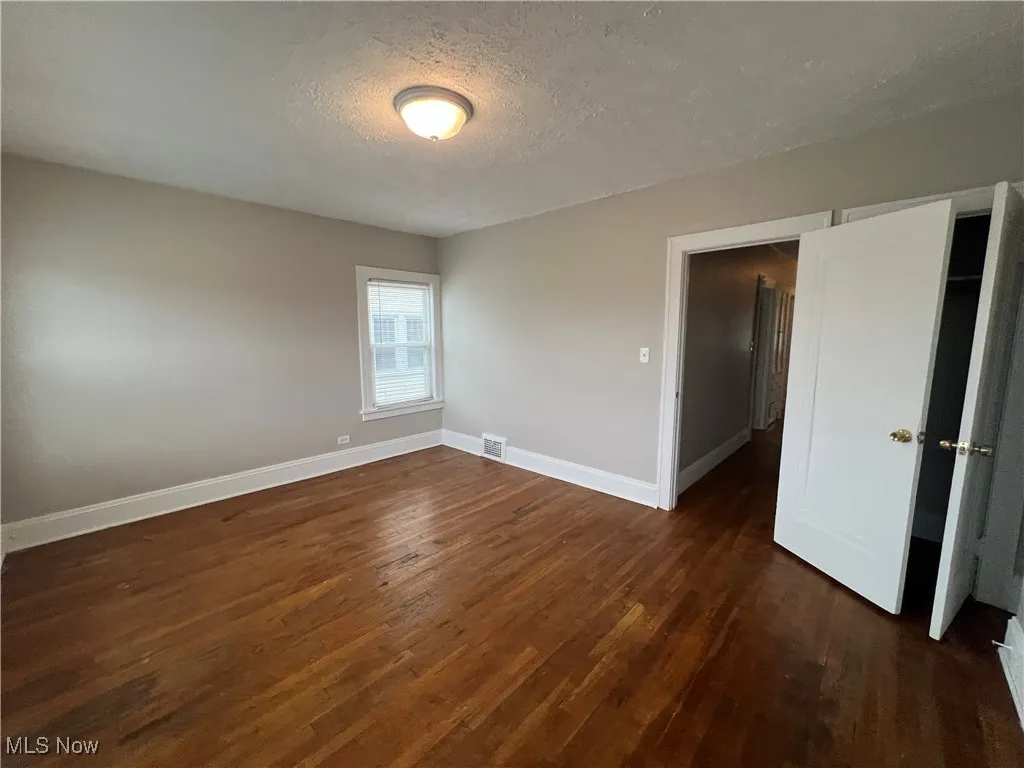 Unfurnished room featuring wood finished floors and a textured ceiling