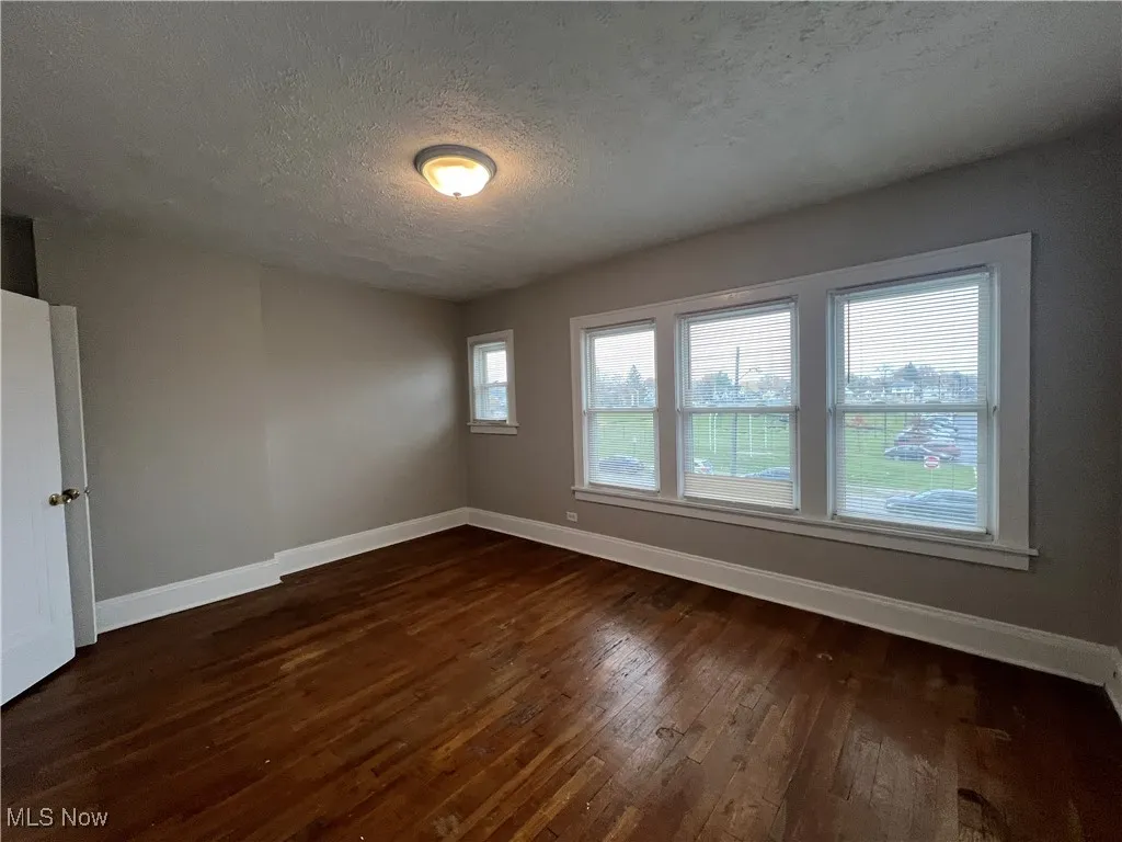 Spare room with dark wood-style floors and a textured ceiling