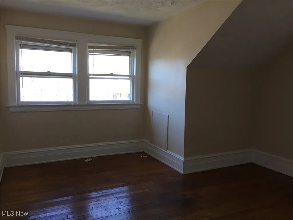 Additional living space with hardwood / wood-style floors and plenty of natural light