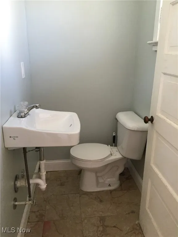 Half bathroom featuring toilet and a sink