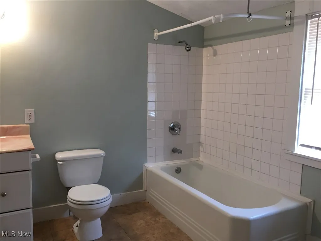 Full bath with vanity, shower / bath combination, and tile patterned flooring