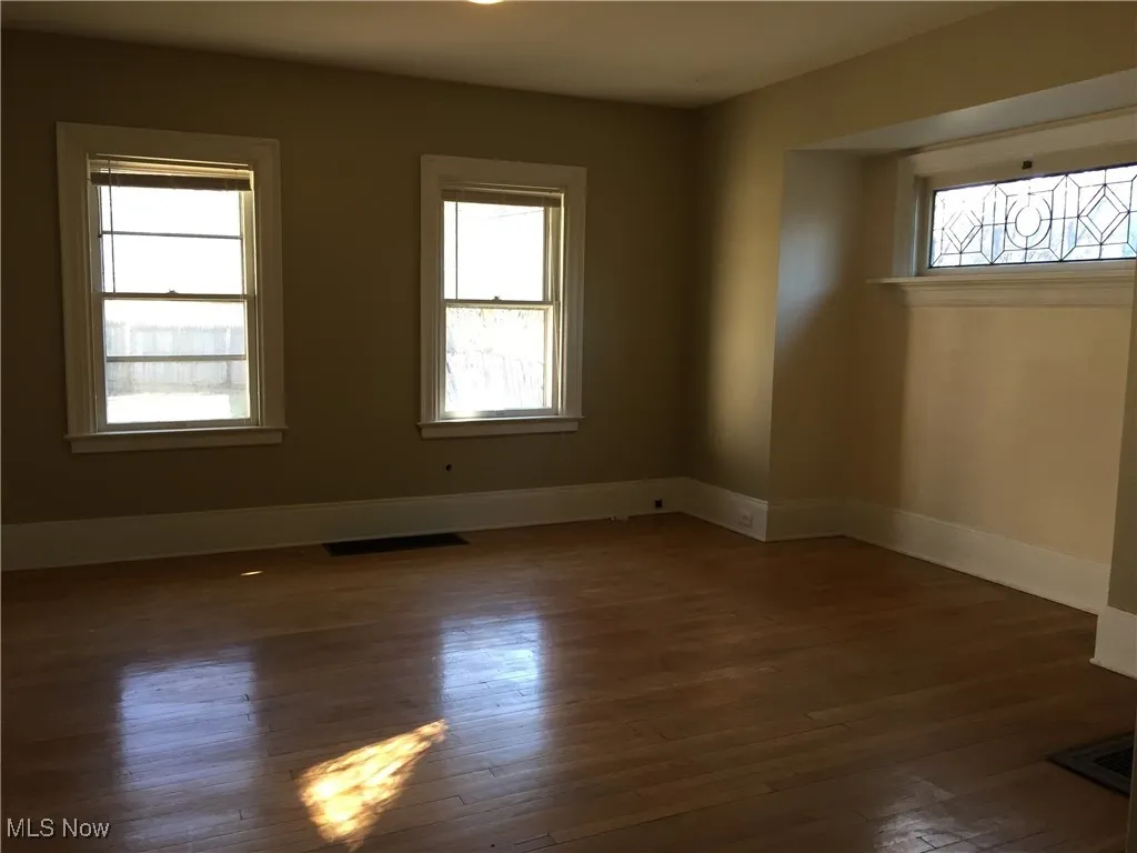 Empty room featuring hardwood / wood-style flooring and baseboards