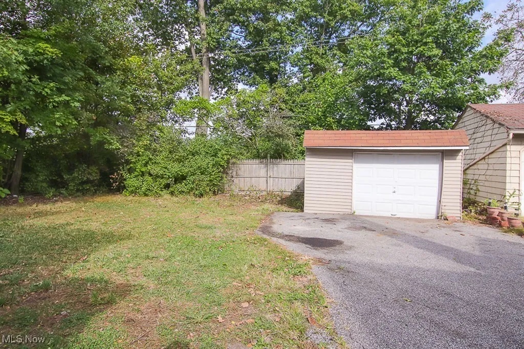 View of yard featuring asphalt driveway and a garage