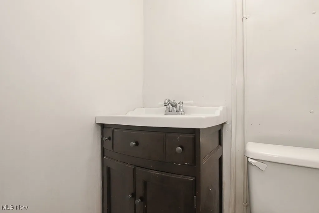 Half bathroom featuring vanity and toilet