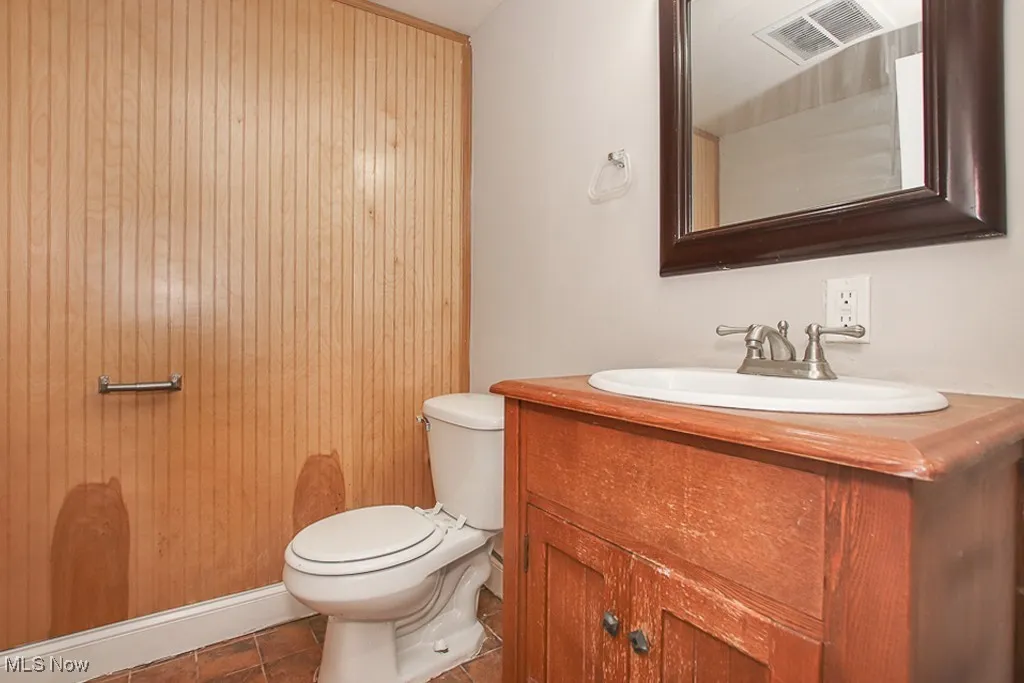 Half bathroom featuring vanity and toilet