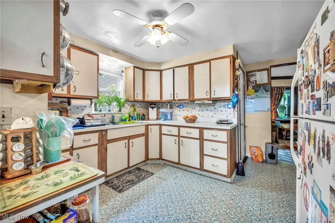 Kitchen featuring a ceiling fan, light countertops, and freestanding refrigerator