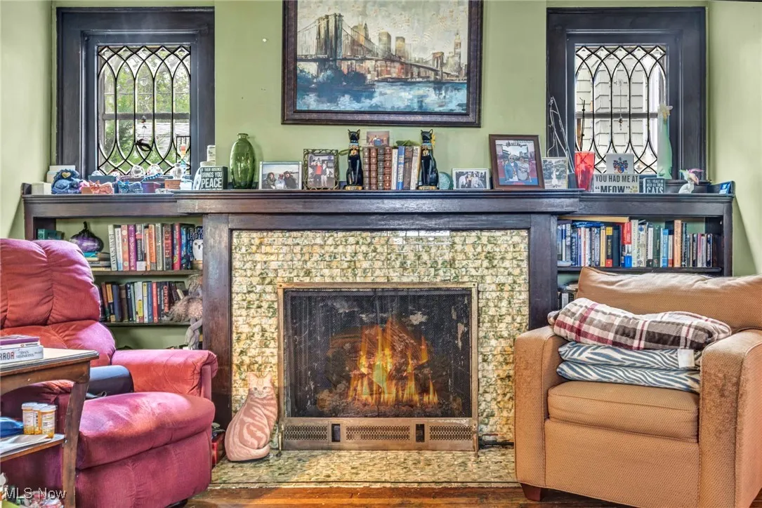Living area with a lit fireplace and wood finished floors