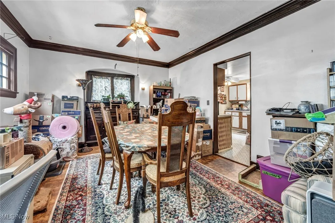 Dining space featuring a ceiling fan, wood finished floors, and crown molding