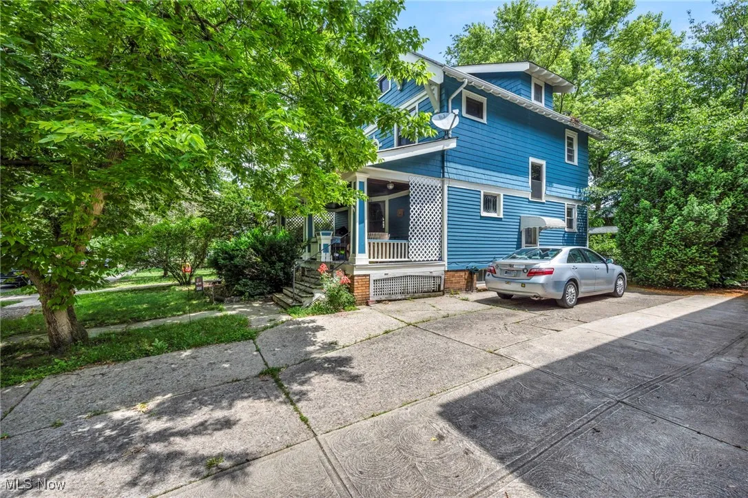 View of side of property featuring a porch and driveway
