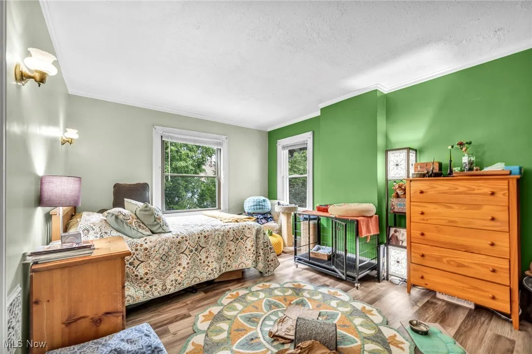 Bedroom featuring ornamental molding, wood finished floors, and a textured ceiling