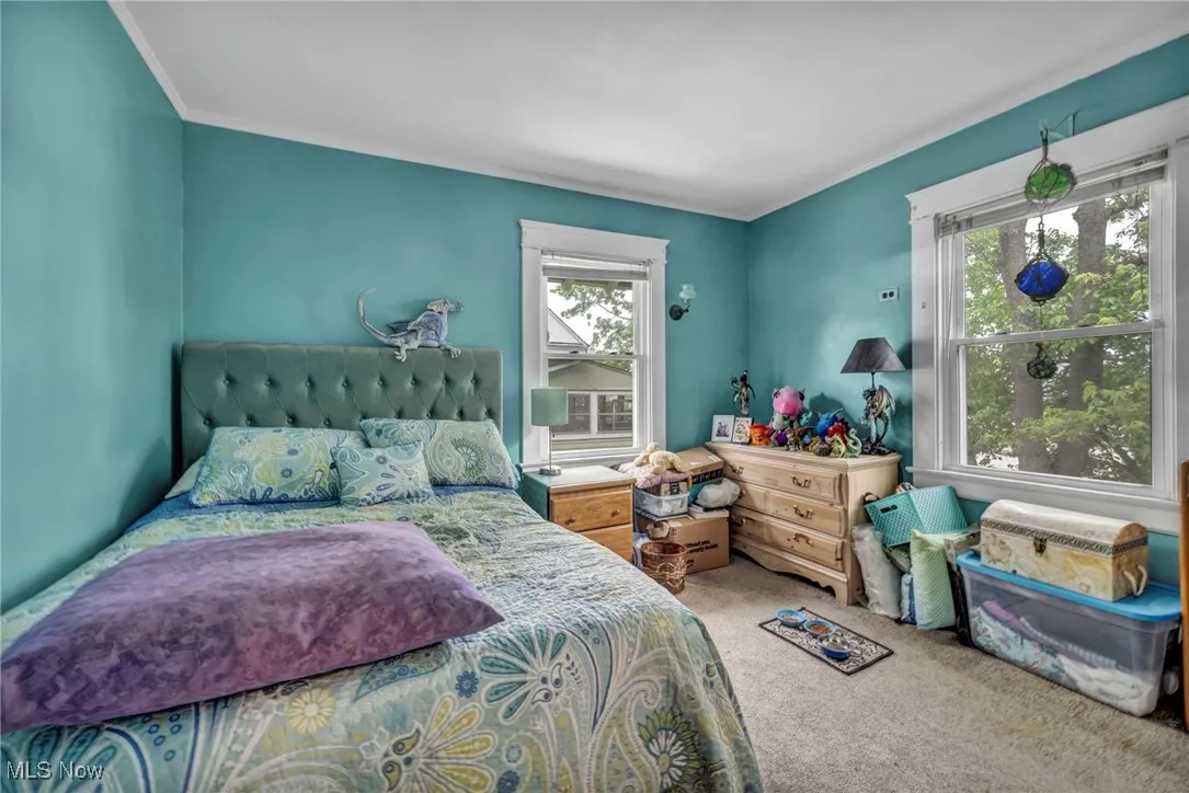 Carpeted bedroom featuring crown molding