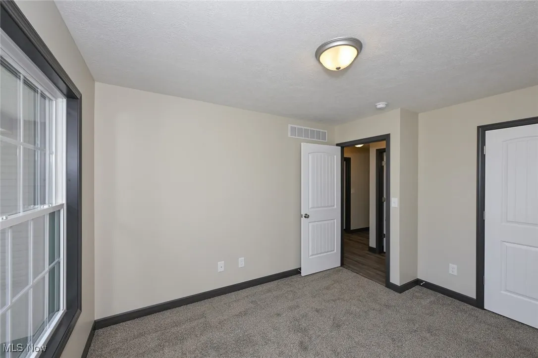 Unfurnished bedroom featuring carpet floors and a textured ceiling