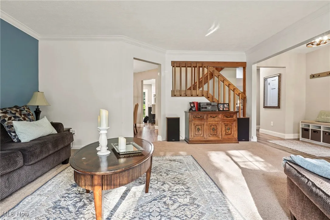 Living room with stairway and ornamental molding