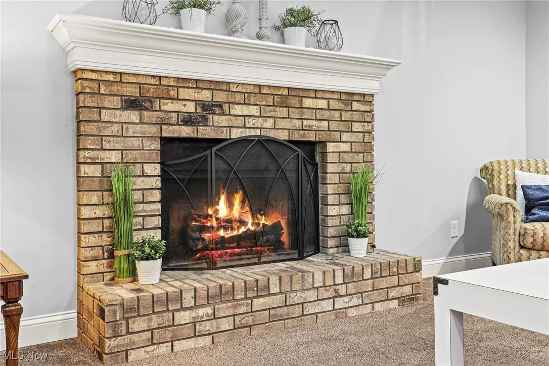 Detailed view of carpet flooring and a brick fireplace