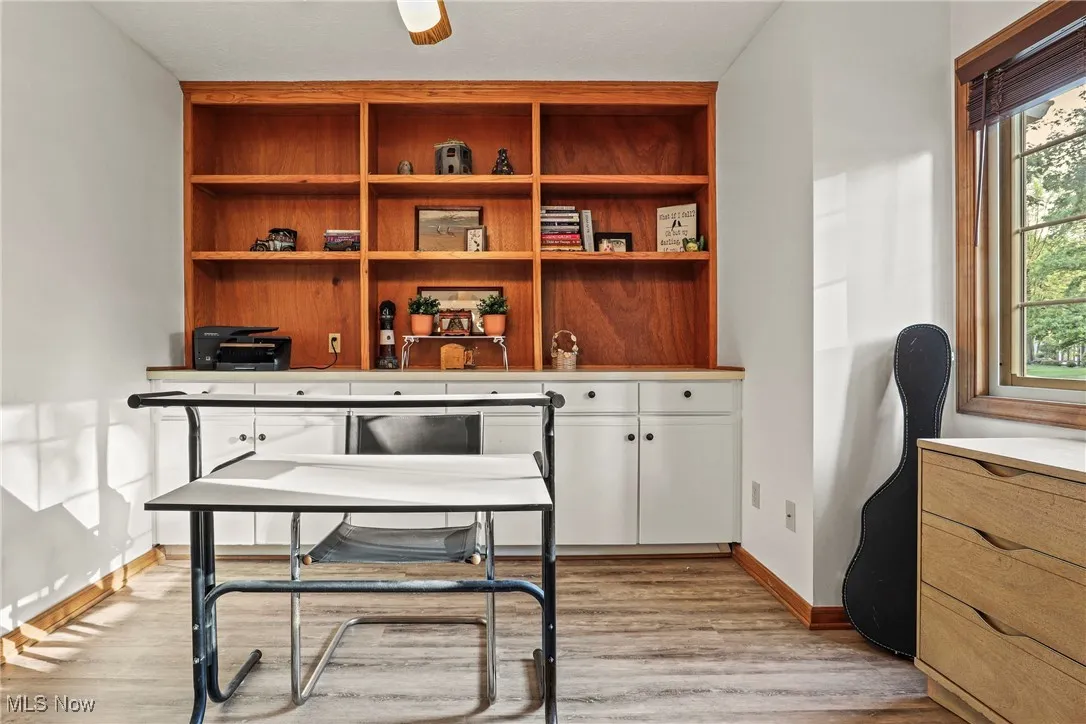 Office with light wood-type flooring and baseboards