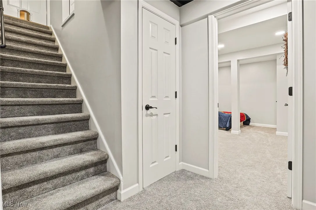 Stairway with carpet flooring and baseboards