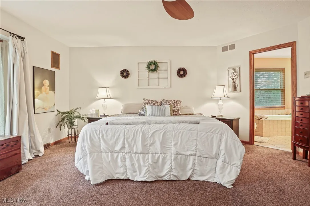 Carpeted bedroom featuring ensuite bathroom