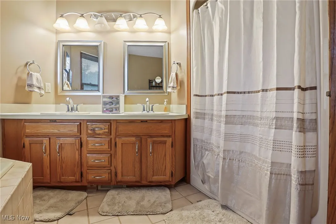 Bathroom with double vanity and tile patterned flooring