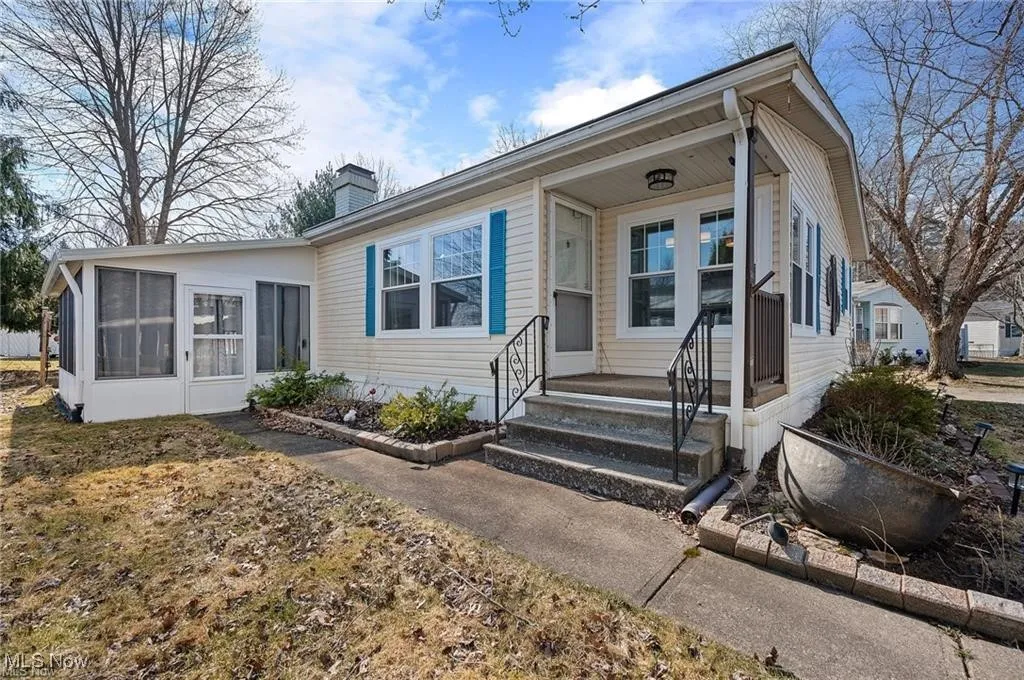 View of front of home featuring a chimney and a sunroom