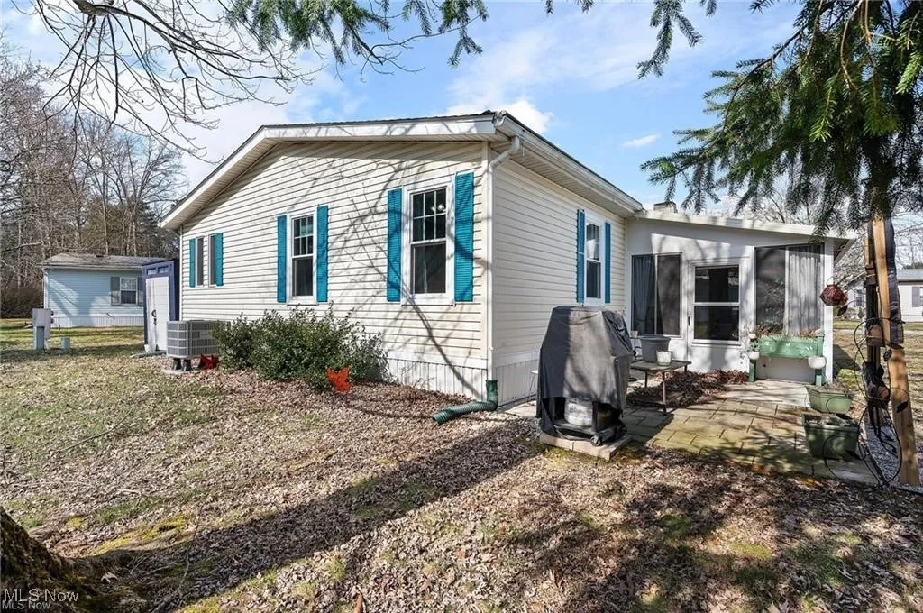 View of side of property with a sunroom and a patio area