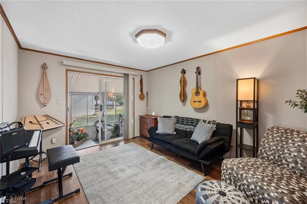 Living room featuring ornamental molding and wood finished floors