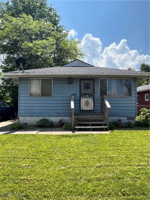 Bungalow-style home featuring a front yard, roof with shingles, and crawl space