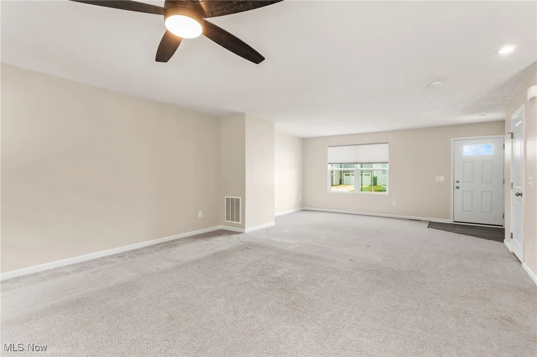 Empty room with carpet flooring and ceiling fan