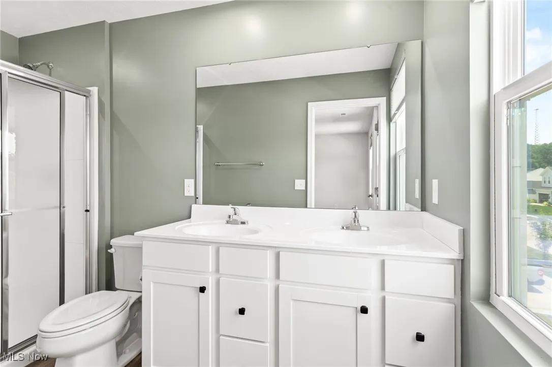 Bathroom featuring double vanity and a stall shower