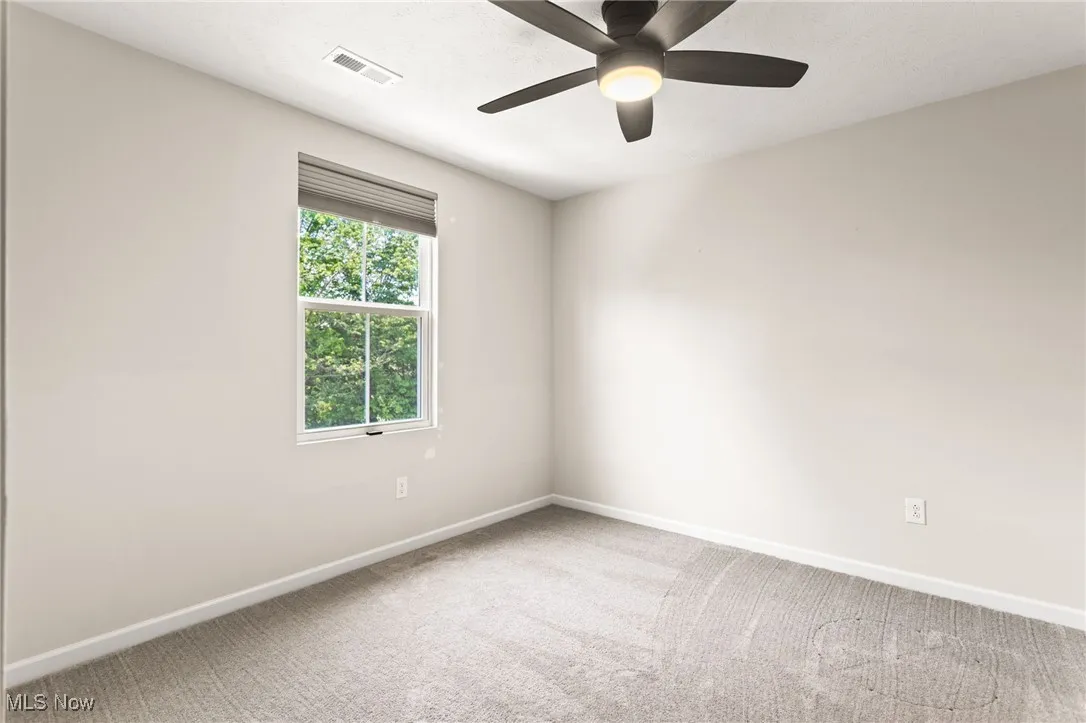 Unfurnished room featuring carpet floors and a ceiling fan