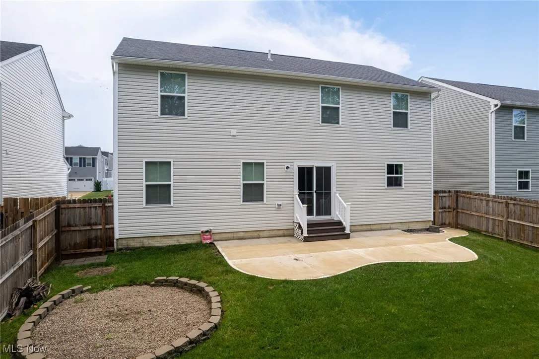 Back of house with entry steps, a patio area, and a fenced backyard