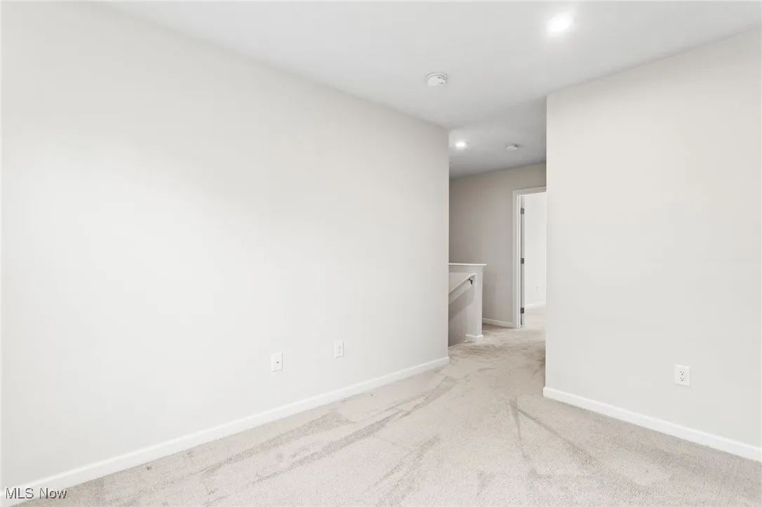 Carpeted spare room featuring recessed lighting and a smoke detector