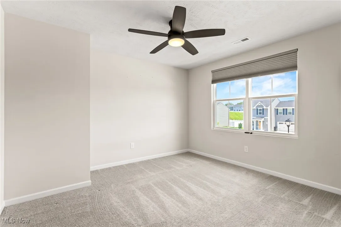 Spare room featuring carpet floors and ceiling fan