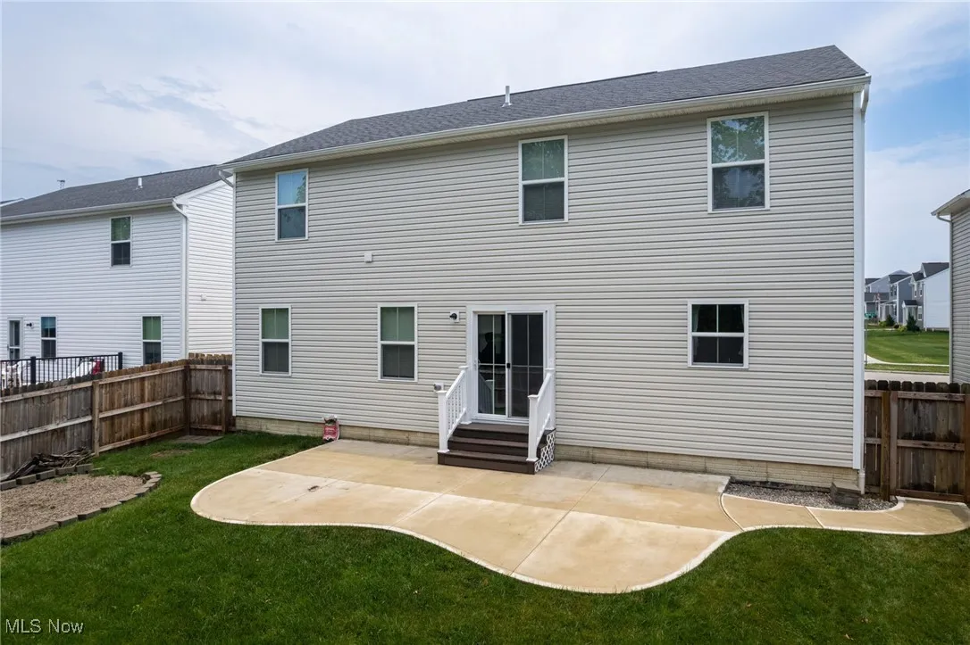 Rear view of house with entry steps, a patio, and a fenced backyard