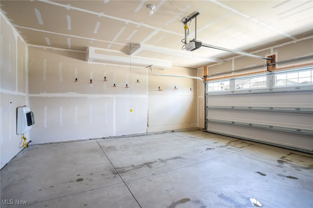 Garage featuring a garage door opener and heating unit