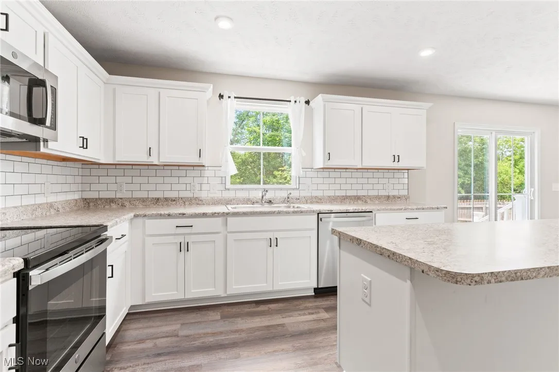 Kitchen with appliances with stainless steel finishes, light wood-style floors, plenty of natural light, light countertops, and recessed lighting