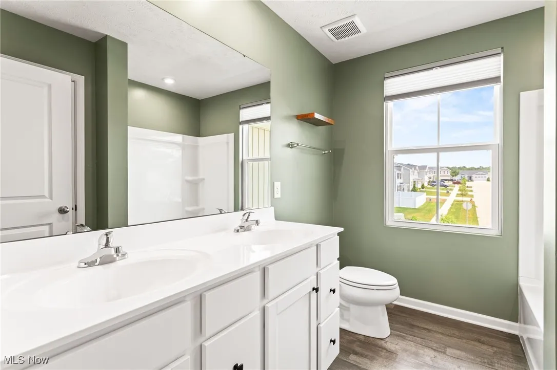 Bathroom with double vanity and wood finished floors