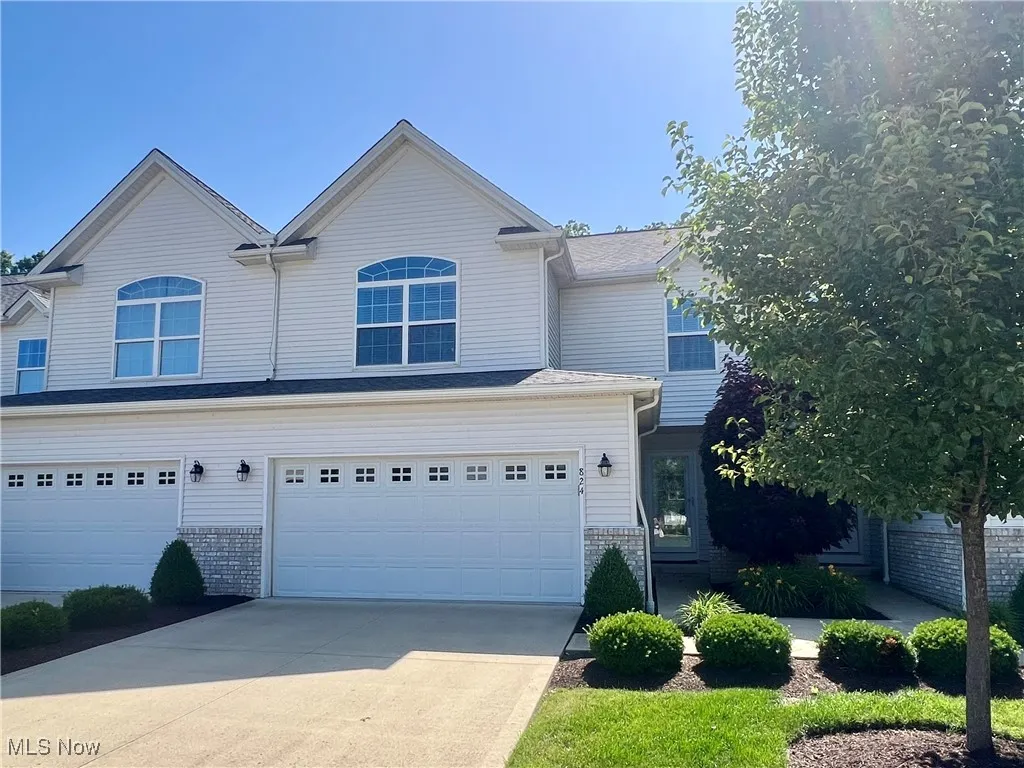 View of front of home featuring concrete driveway, a garage, and brick siding